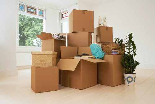 Movers carrying boxed household items through a Knightsbridge apartment building